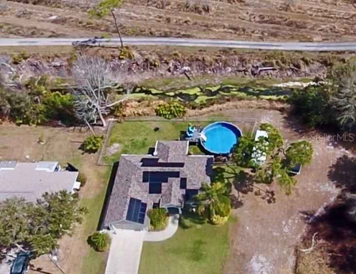 An aerial view shows a house with a shingled roof, a circular pool, and driveway — 478 HUMPHREY AVENUE, LAKE PLACID, FL