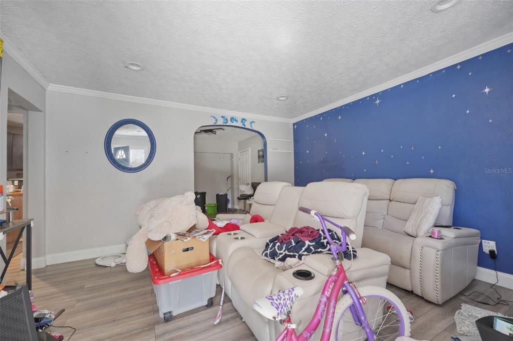 A living room features light gray walls, a blue accent wall with star decals, and flooring — 1324 PLACID PLACE, JACKSONVILLE, FL