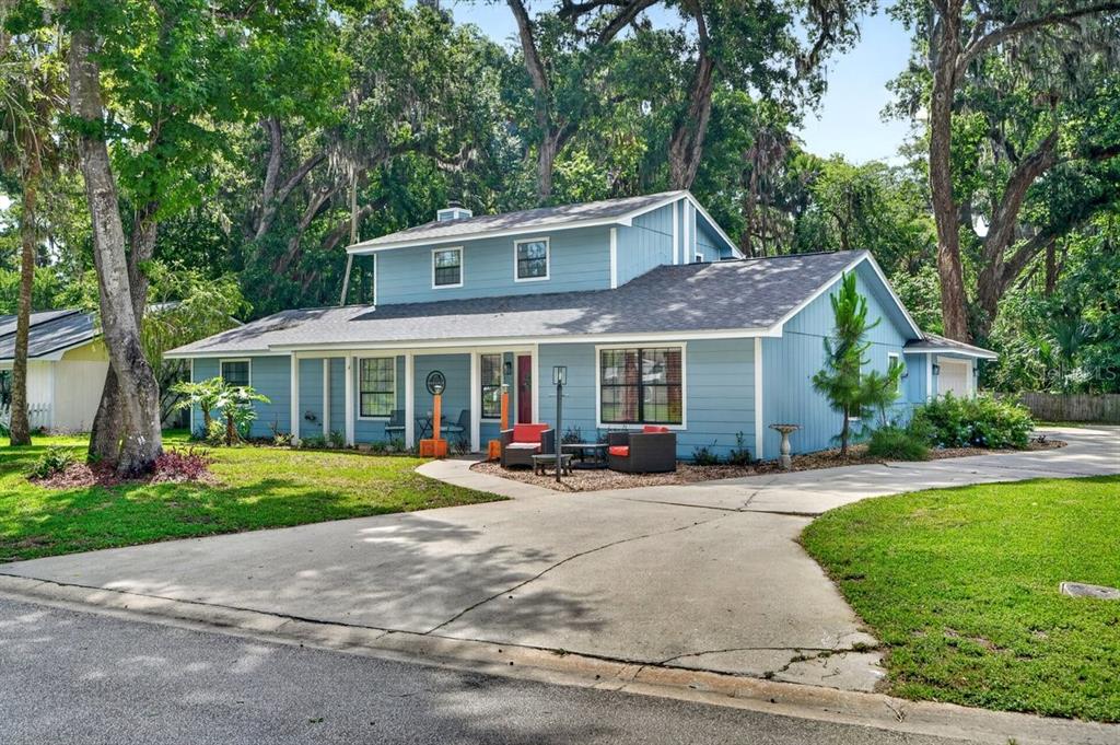 A two-story blue house with a concrete driveway and large trees in the front yard — 855 SUGAR HOUSE DRIVE, PORT ORANGE, FL