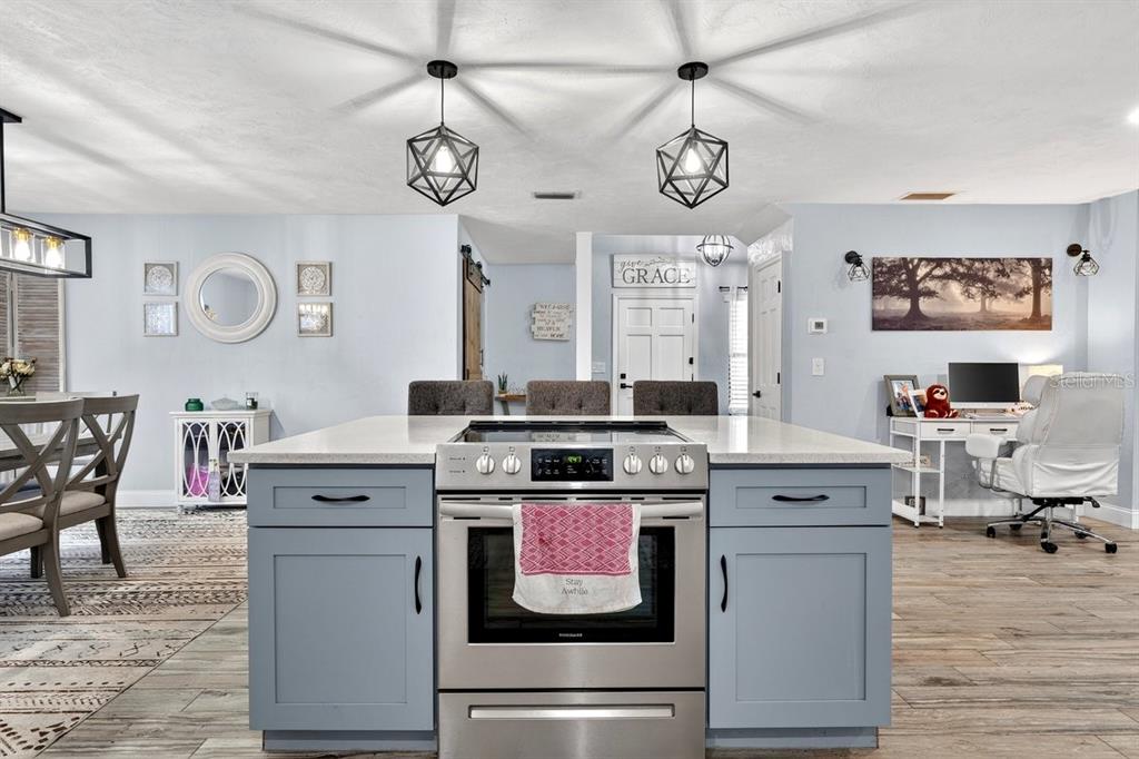 A kitchen island with a stainless steel range sits in front of a home office — 855 SUGAR HOUSE DRIVE, PORT ORANGE, FL