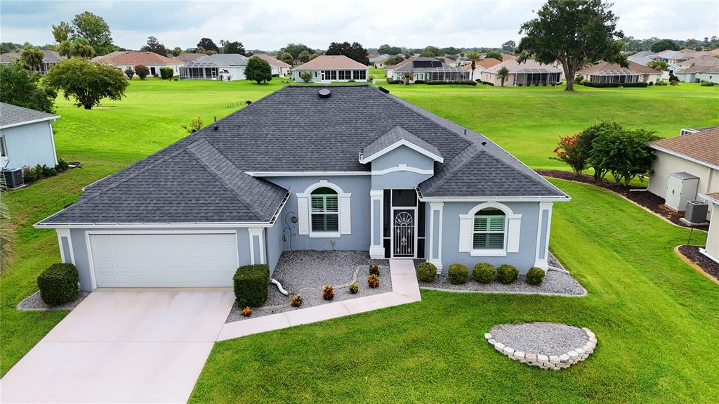 An aerial view of a single-story gray house with a dark shingled roof and garage — 2293 NW 58TH TERRACE, OCALA, FL