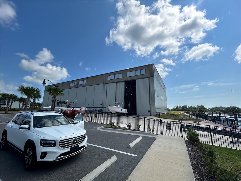 A white SUV is parked in front of a large metal boat storage building — 24 DEL PALMA DRIVE, PALM COAST, FL
