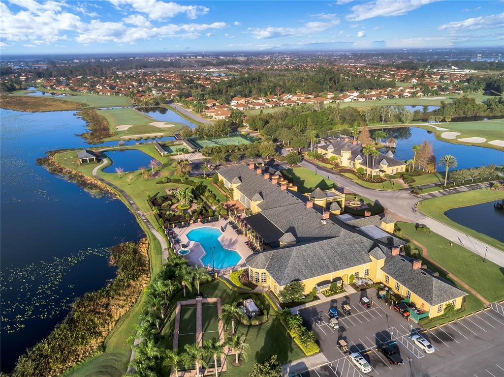 Aerial view of a clubhouse complex featuring a swimming pool, tennis courts, and parking lot — 4436 WATERFORD DRIVE, LAKE WALES, FL