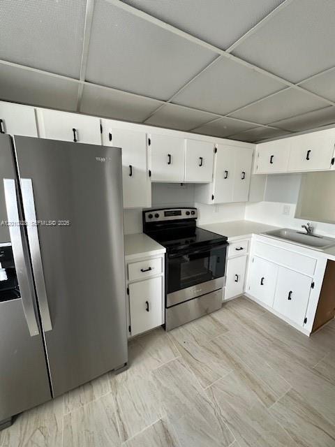 A kitchen features white cabinets, stainless steel appliances, and light-colored tile flooring — 3571 Inverrary Dr # 202, Lauderhill FL 33319, LAUDERHILL, FL