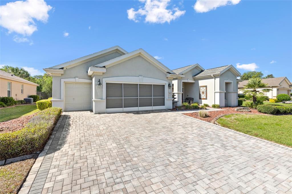 A single-story house features a paved driveway, a two-car garage, and a covered entryway — 13932 SE 96TH CIRCLE, SUMMERFIELD, FL