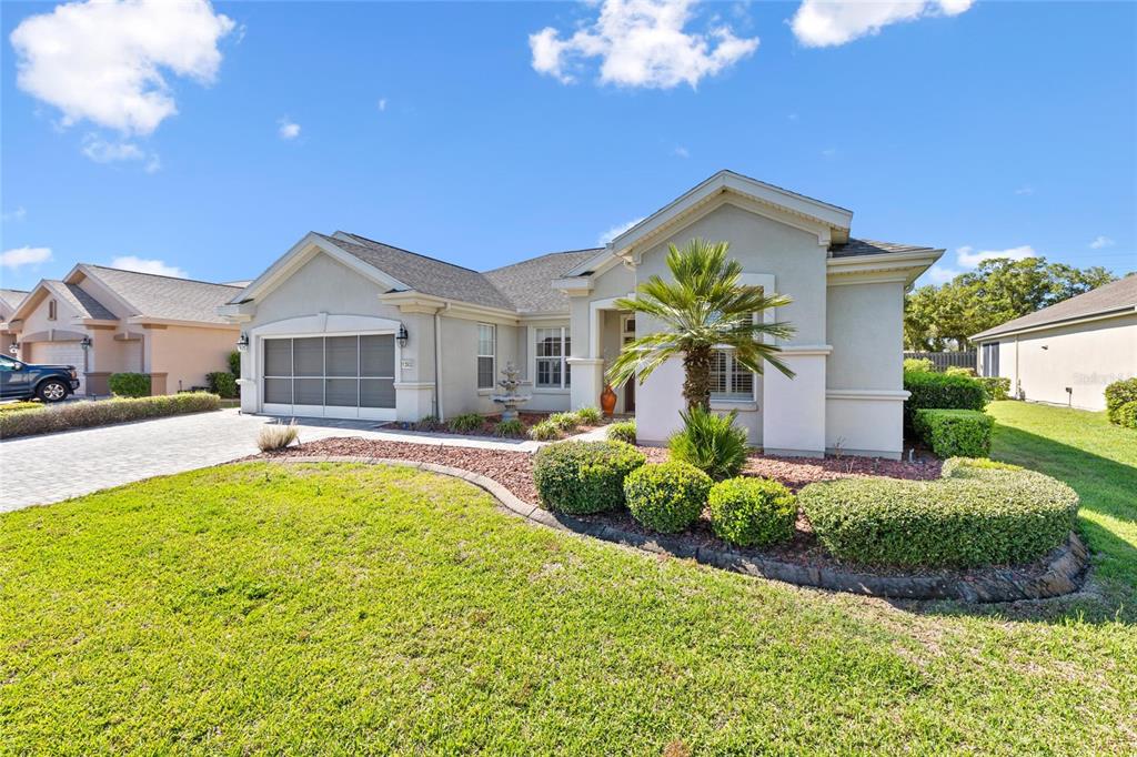 A single-story house with a paved driveway, a two-car garage, and a landscaped front yard — 13932 SE 96TH CIRCLE, SUMMERFIELD, FL