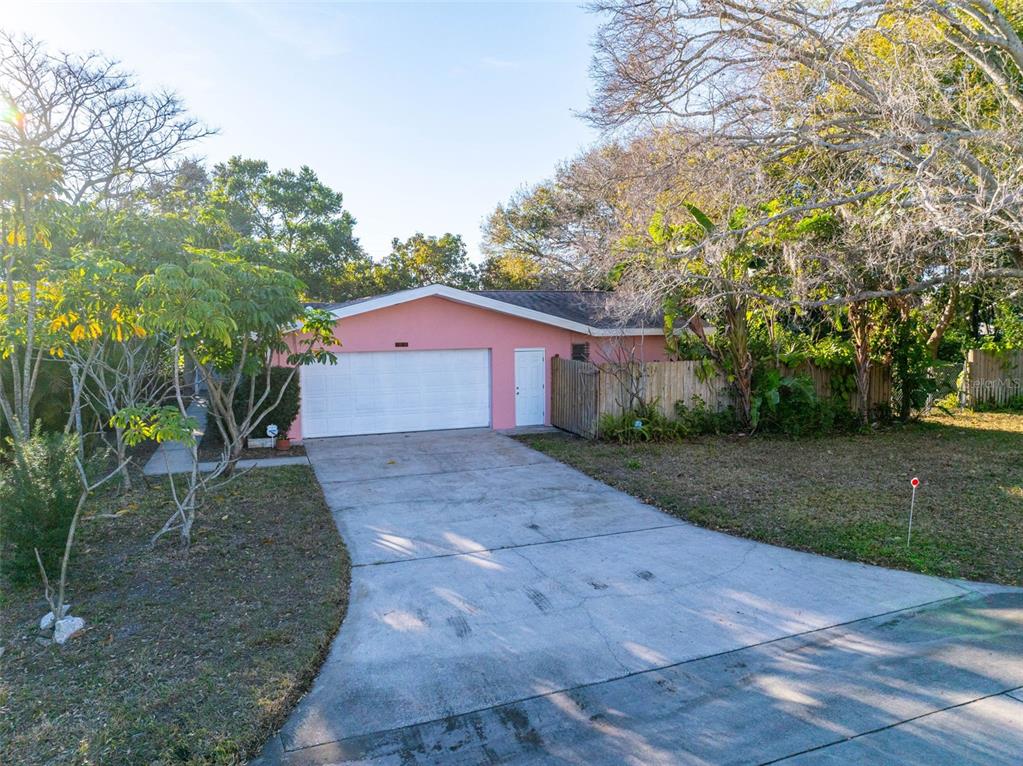 A pink house with a two-car garage and a concrete driveway sits on a lot — 1546 BELLEAIR ROAD, CLEARWATER, FL