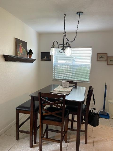 A dining area features a dark wood table with chairs and a bench under a chandelier — 348 Monaco H, Delray Beach FL 33446, DELRAY BEACH, FL