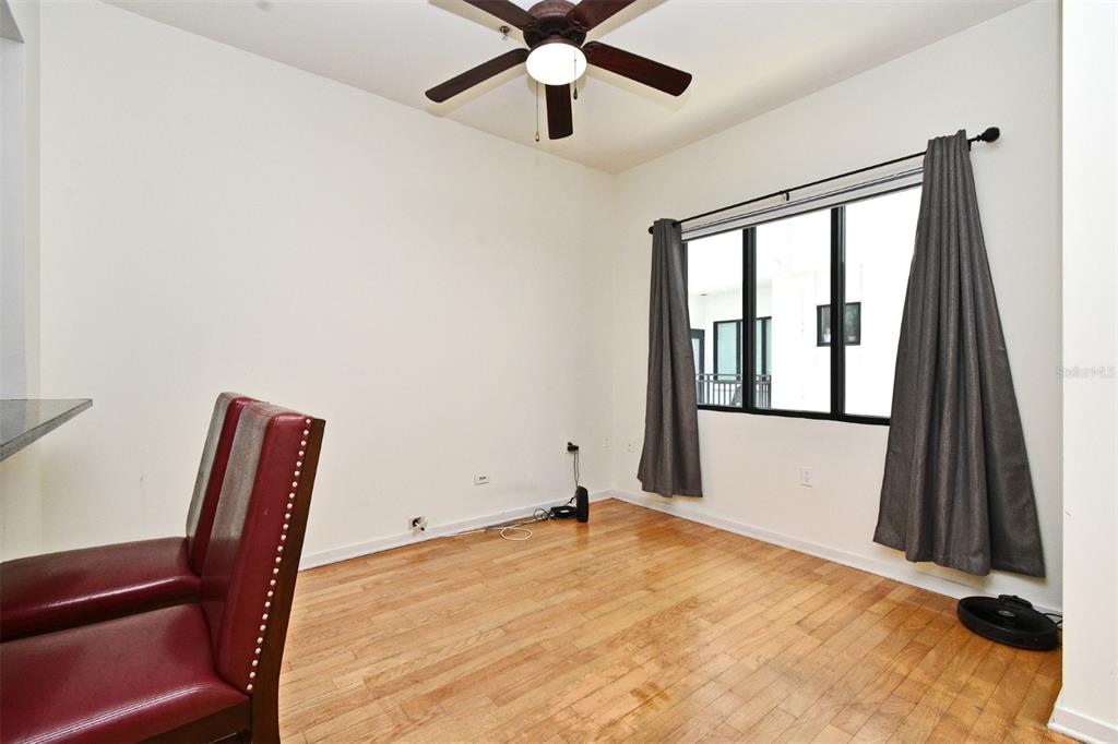 A room with hardwood floors, a ceiling fan, and a window with gray curtains — 460 E JACKSON STREET UNIT 5, ORLANDO, FL