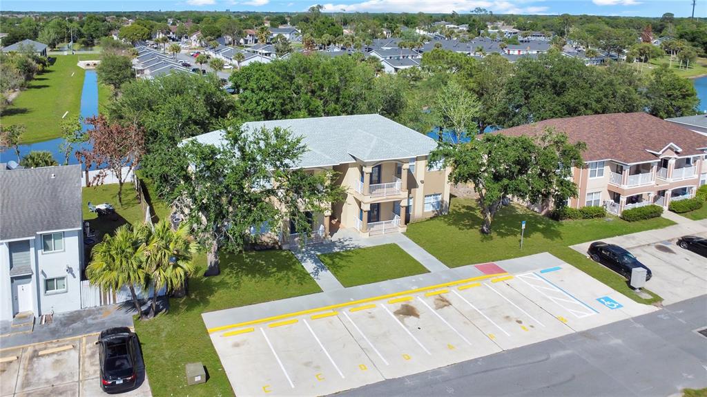 An aerial view shows a two-story apartment building with a parking lot in front — 206 MAJORS LANE UNIT D, KISSIMMEE, FL