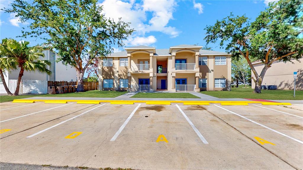 A two-story apartment building with a parking lot in the foreground — 206 MAJORS LANE UNIT D, KISSIMMEE, FL