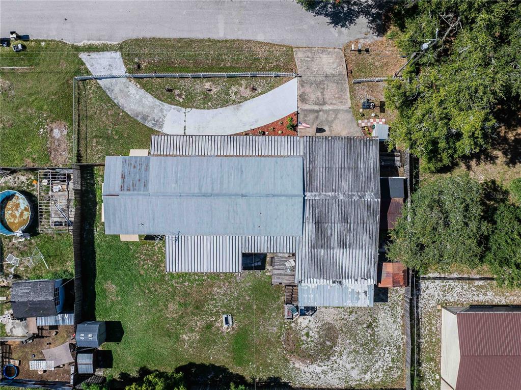 An aerial view shows a house with a metal roof, a driveway, and a backyard — 3140 4TH STREET, DAVENPORT, FL