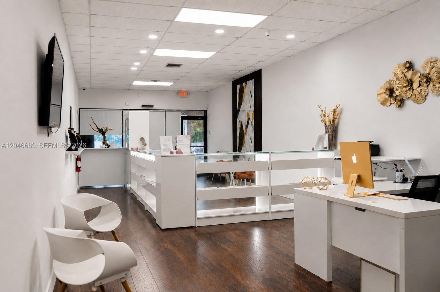 A bright commercial office space features white display counters, modern chairs, and wood flooring — 1341 N PALM AVE, Miramar FL 33024, MIRAMAR, FL