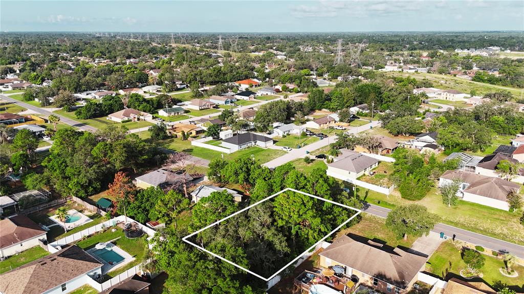 An aerial view shows a wooded, rectangular vacant lot surrounded by residential houses — 3581 LEMA DRIVE, SPRING HILL, FL