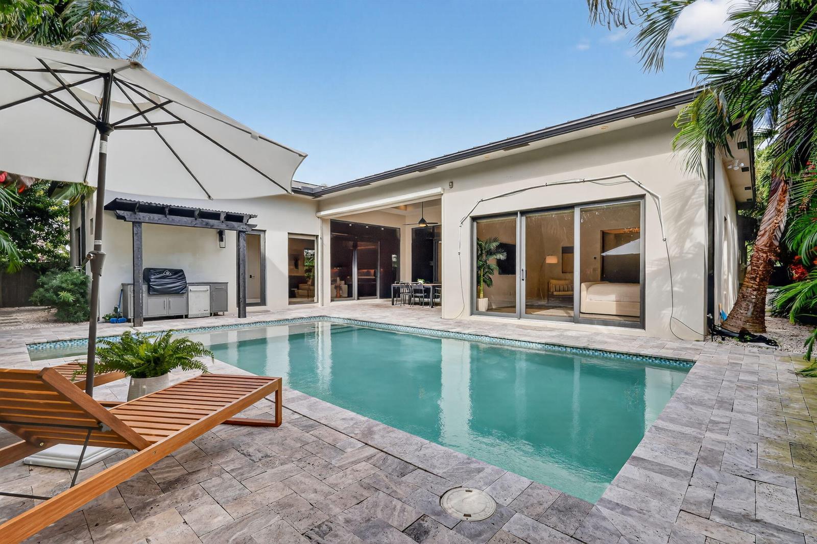 A backyard features a swimming pool, a patio with lounge chairs, and a covered grill area — 718 NW 5th Avenue, Delray Beach FL 33444, DELRAY BEACH, FL