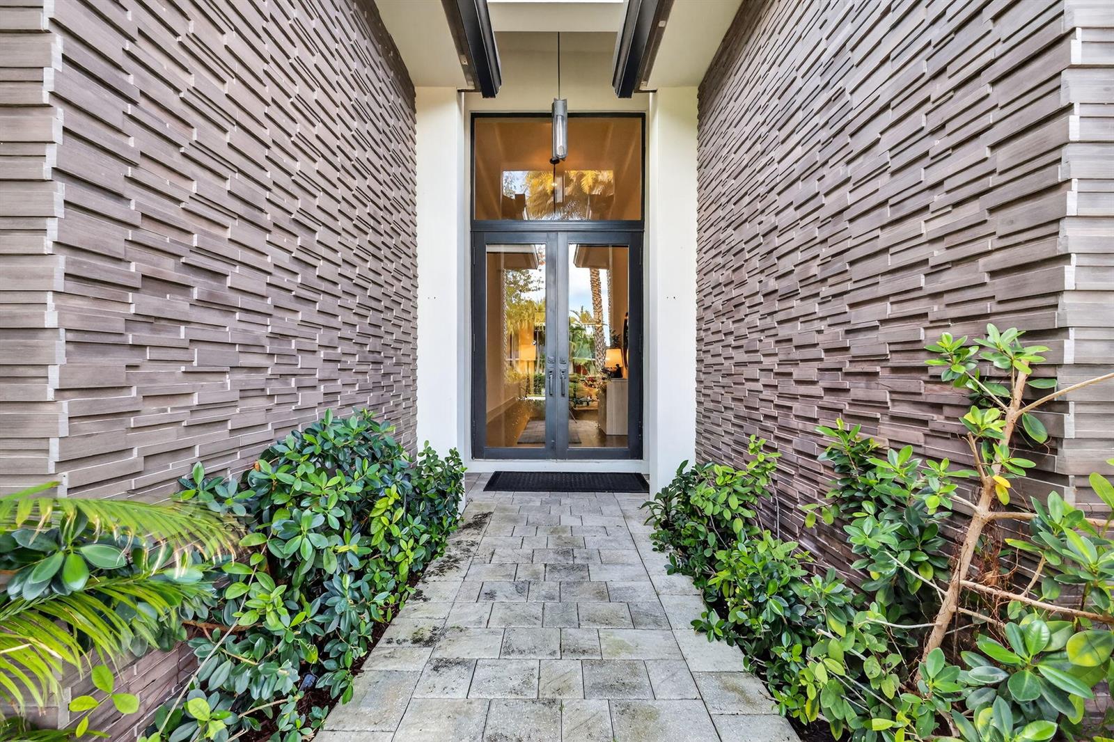A stone-paved walkway leads to a double glass front door flanked by textured stone walls — 718 NW 5th Avenue, Delray Beach FL 33444, DELRAY BEACH, FL