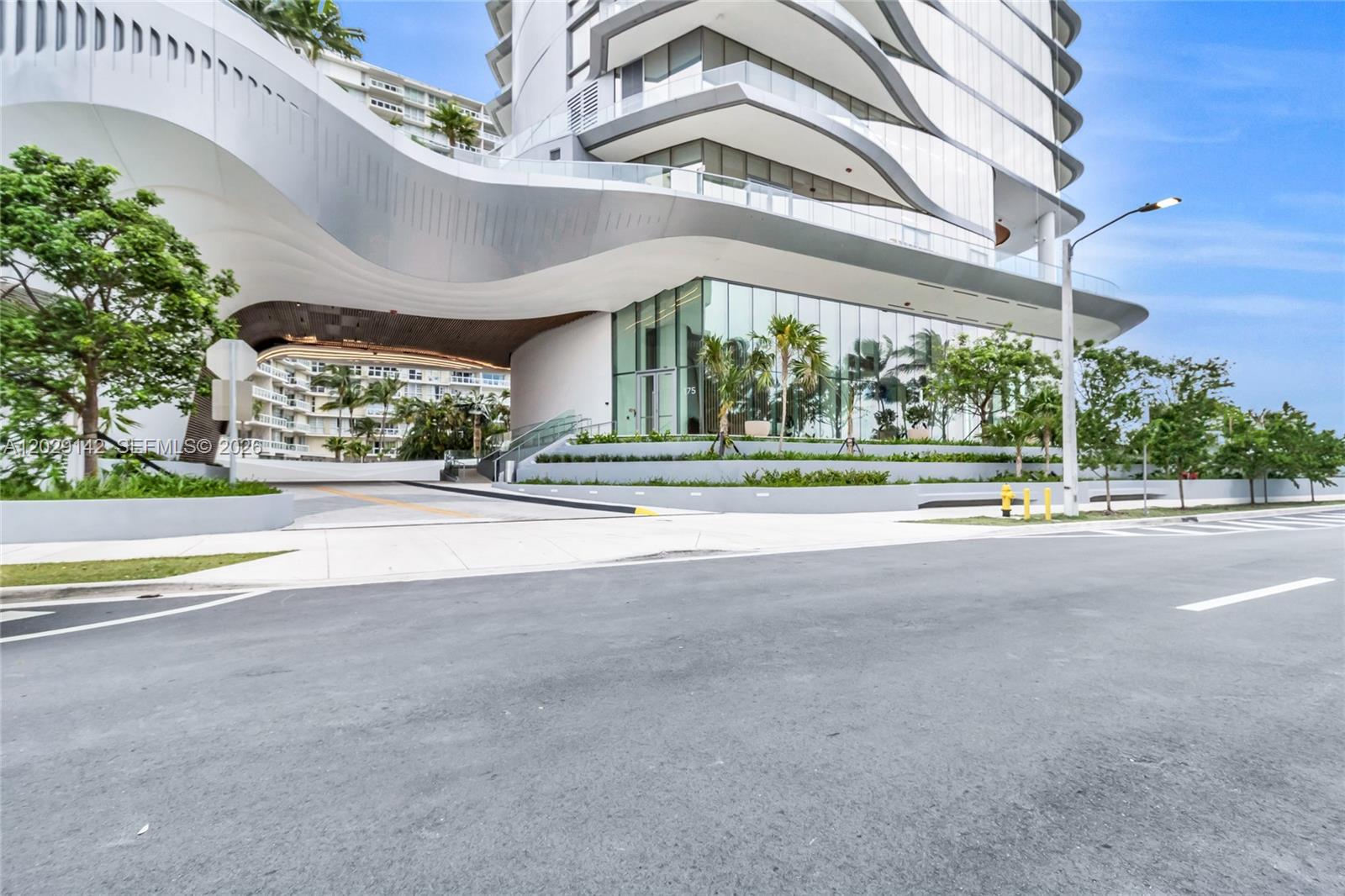 A modern high-rise building features a curved white canopy over a driveway and glass facade — 175 SE 25 Rd # 1103, Miami FL 33129, MIAMI, FL