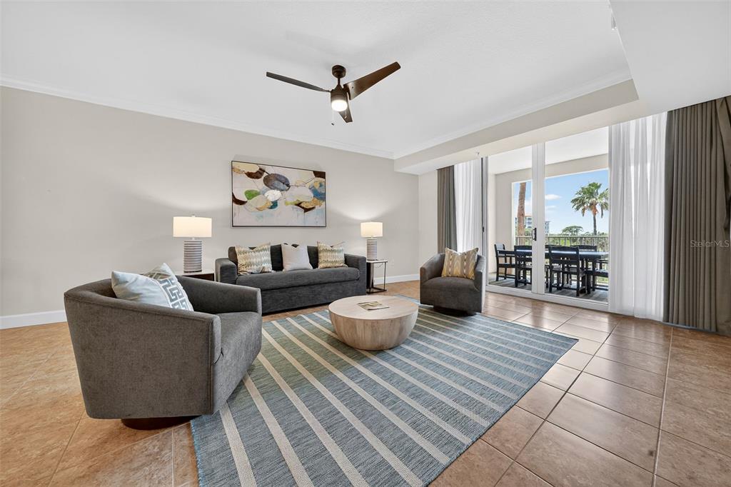 A living room features tile floors, a striped area rug, and a balcony with outdoor seating — 102 YACHT HARBOR DRIVE UNIT 365, PALM COAST, FL