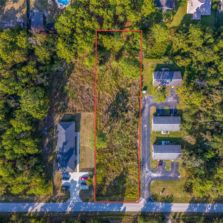 An aerial view shows a rectangular vacant lot outlined in red between two residential properties — 000 MIDWAY TERRACE, OCALA, FL