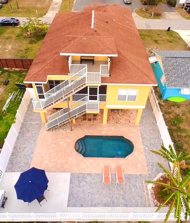 An aerial view shows a yellow house with a pool, patio, and exterior staircase — 7322 SHEEPSHEAD DRIVE, HUDSON, FL