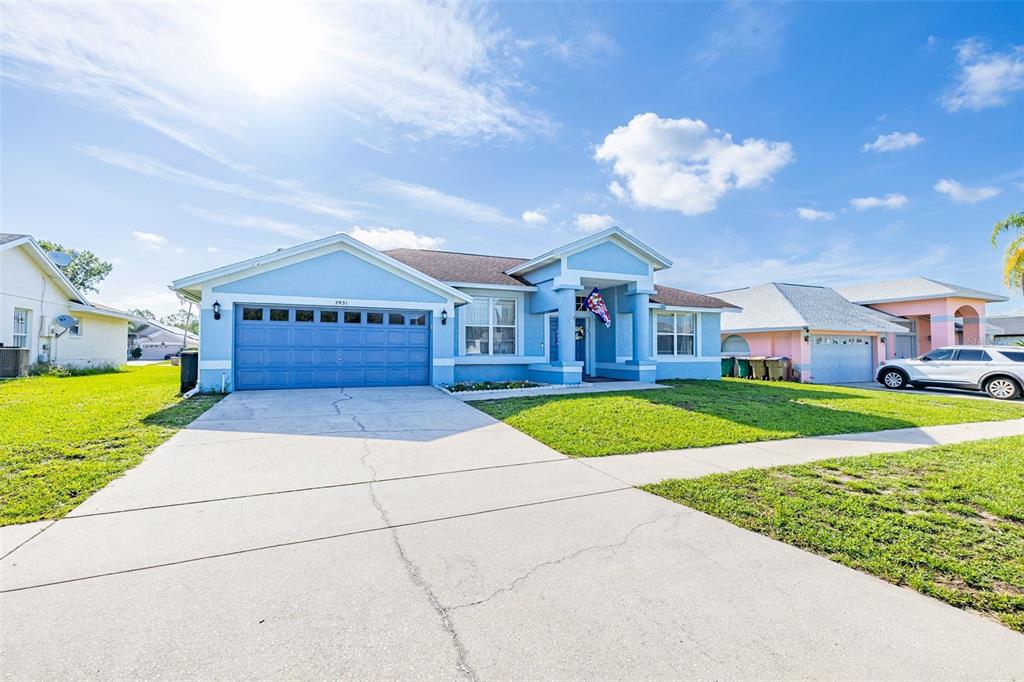 A blue single-story house with a two-car garage and a concrete driveway — 2931 PADDINGTON WAY, KISSIMMEE, FL