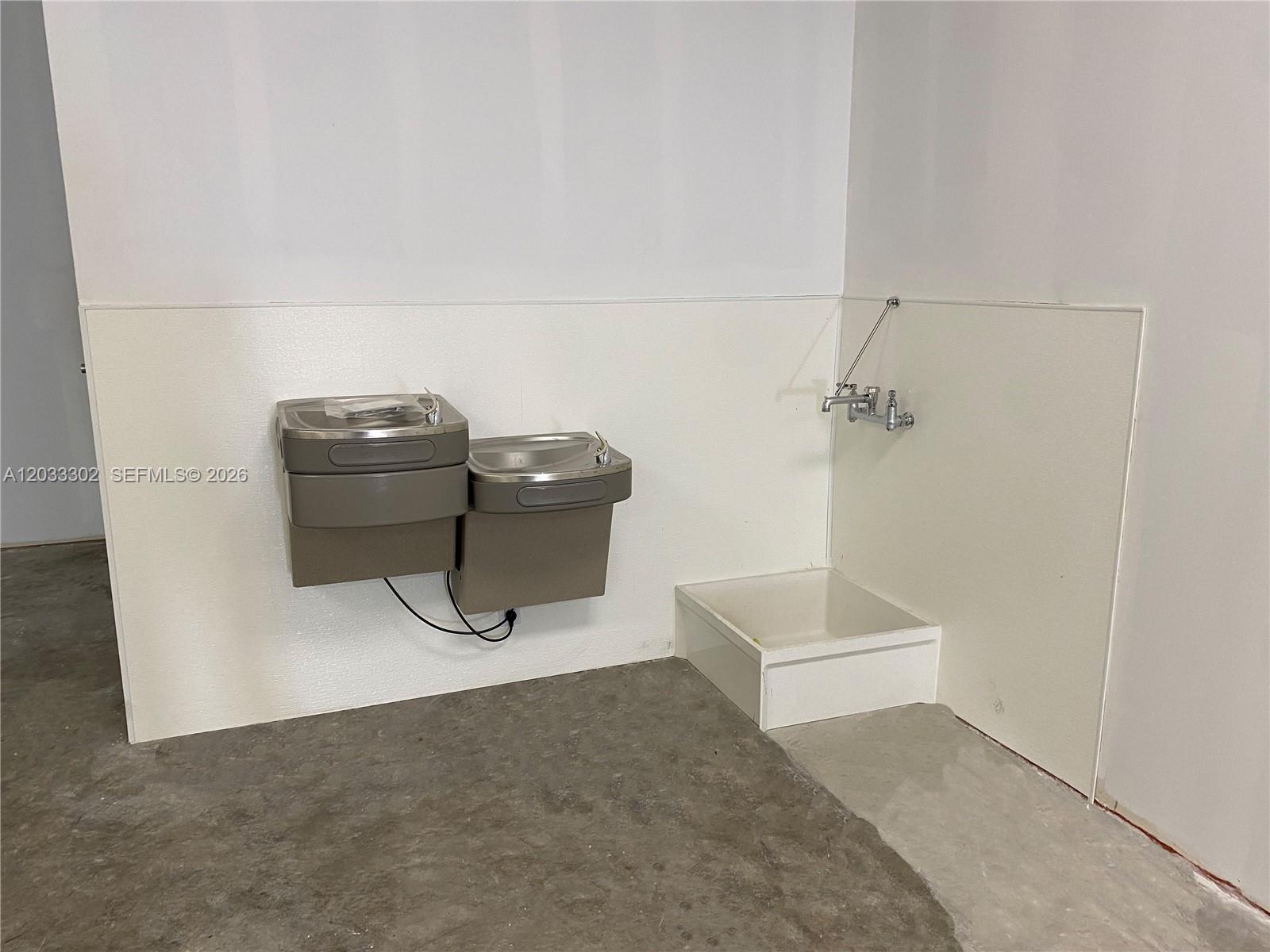 A room features two wall-mounted water fountains and a mop sink with a faucet — 300 SW 17th Ave # 4, Miami FL 33135, MIAMI, FL