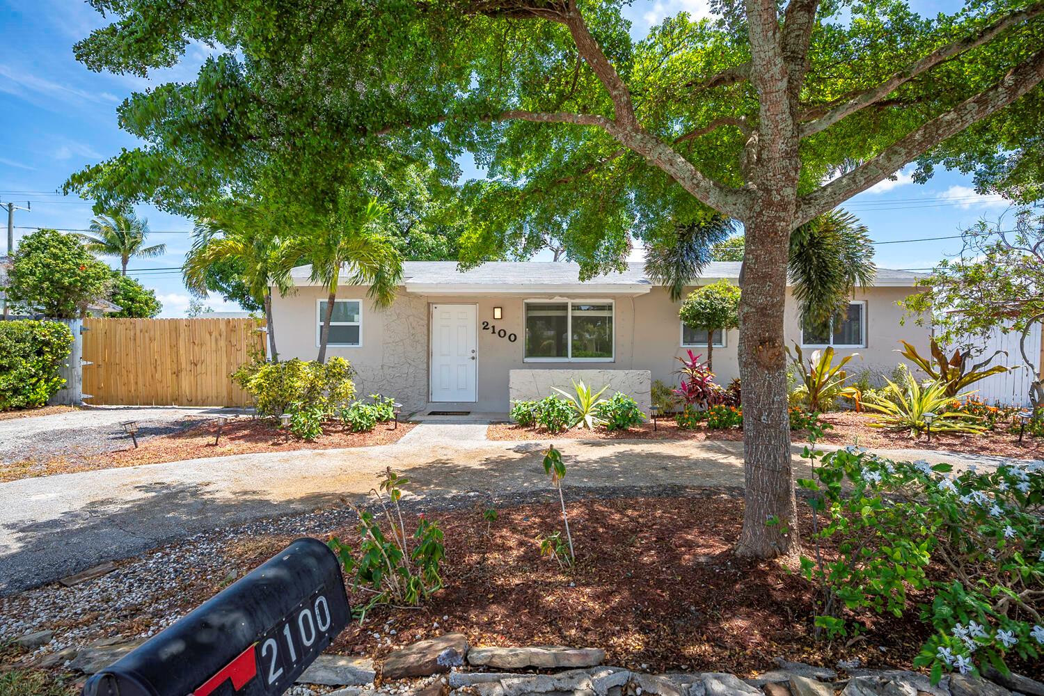 A single-story house with a white door, light-colored stucco walls, and a large tree — 2100 N Seacrest Boulevard, Boynton Beach FL 33435, BOYNTON BEACH, FL