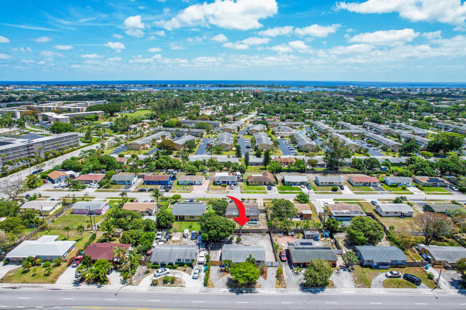 An aerial view of a residential neighborhood with a red arrow pointing to a house — 2100 N Seacrest Boulevard, Boynton Beach FL 33435, BOYNTON BEACH, FL