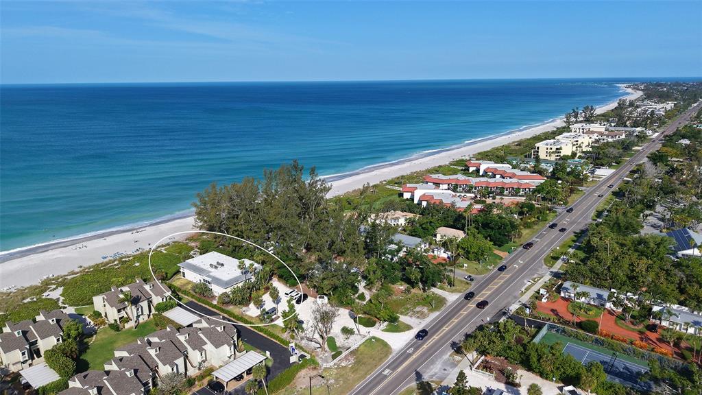 An aerial view shows a white house near a beach, trees, and a coastal road — 5311 GULF OF MEXICO DRIVE UNIT 5, LONGBOAT KEY, FL