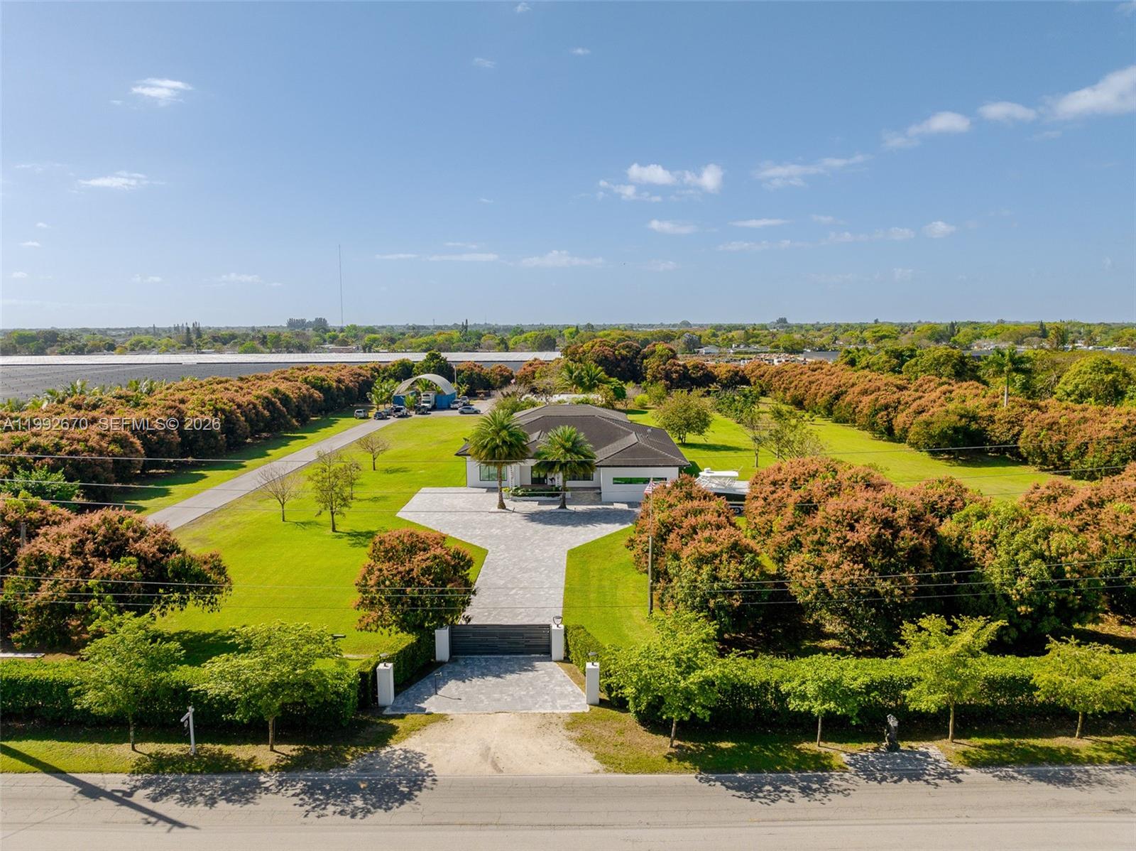 An aerial view shows a house with a paved driveway and large lawn surrounded by trees — 17950 SW 192nd St, Miami FL 33187, MIAMI, FL