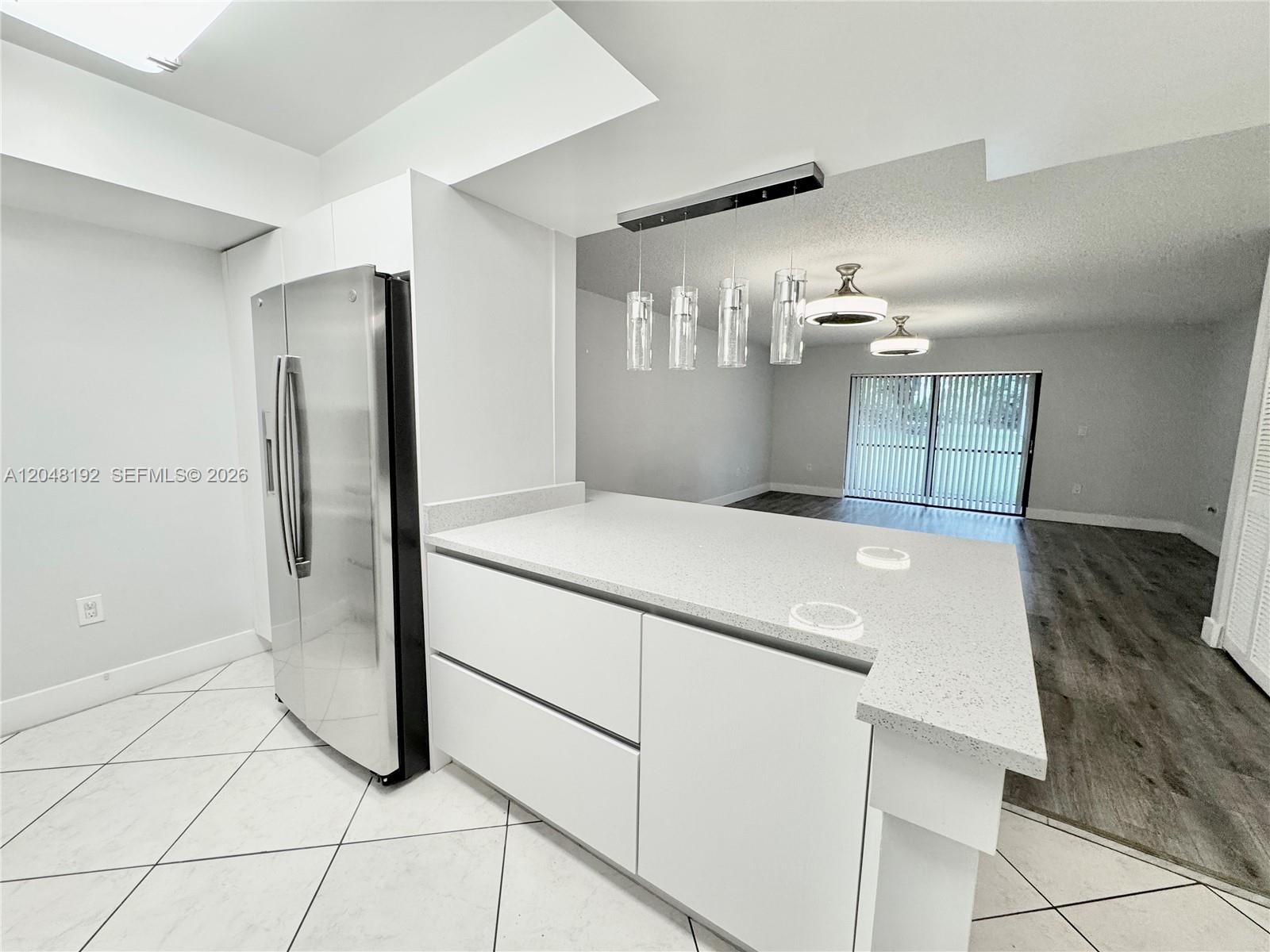 A kitchen with white cabinets, a quartz countertop, and a stainless steel refrigerator — 8600 NW 34th Pl # B102, Sunrise FL 33351, SUNRISE, FL