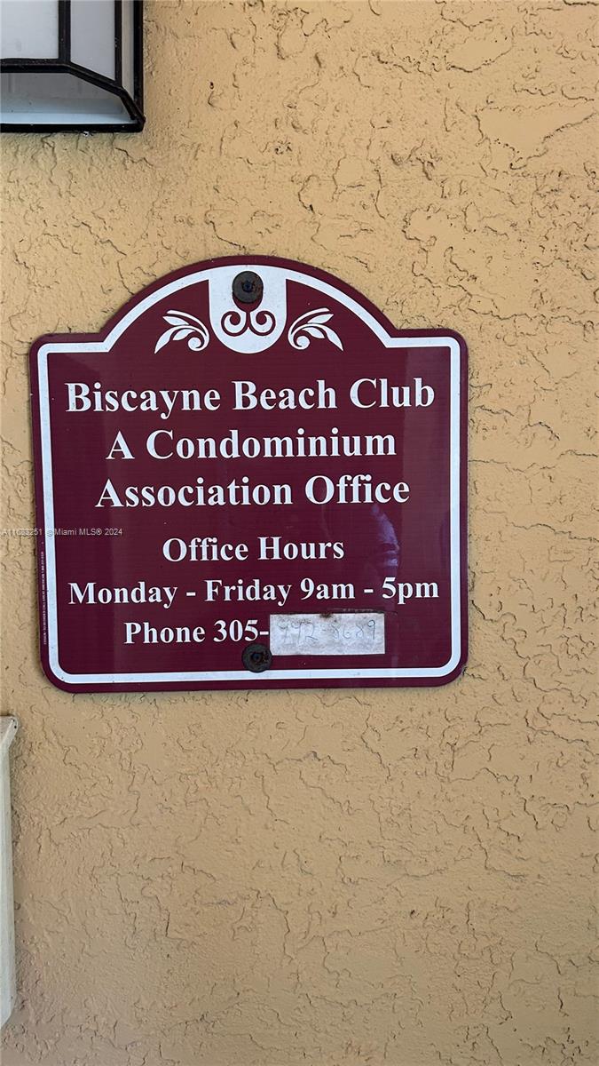 A maroon sign for the Biscayne Beach Club Condominium Association office is mounted on a wall — 15551 SW 104th Ter # 828, Miami FL 33196, MIAMI, FL