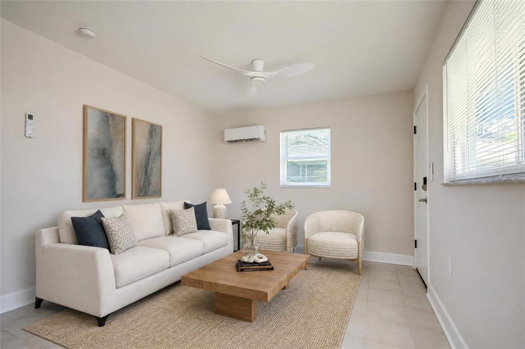 A living room features a white sofa, two armchairs, a wooden coffee table, and ceiling fan — 190 73RD AVENUE UNIT B, ST PETE BEACH, FL