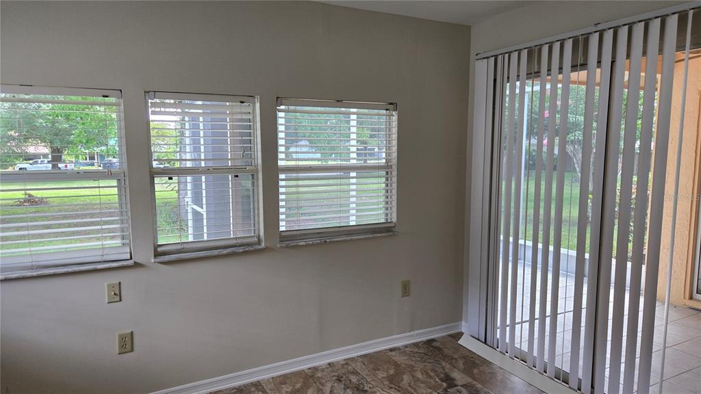 A room with tile flooring, three windows with blinds, and a sliding glass door — 1657 TREMONT LANE, WINTER PARK, FL