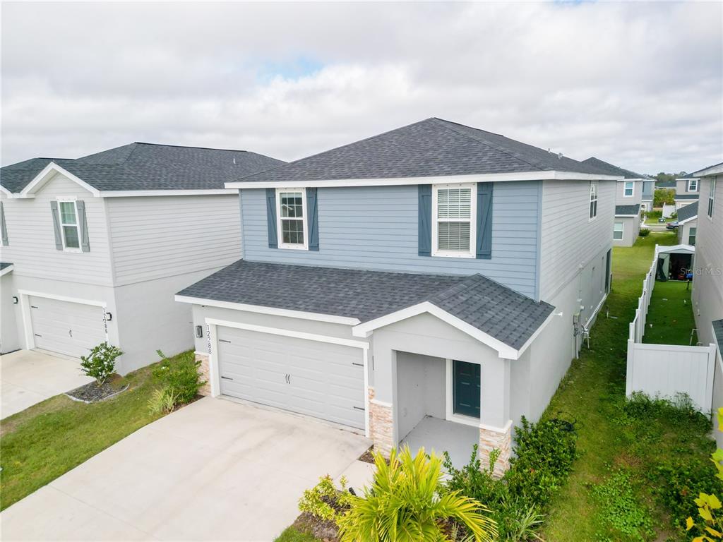 A two-story suburban house with blue siding, a gray shingled roof, and a two-car garage — 12288 CYPRESS BRANCH STREET, RIVERVIEW, FL