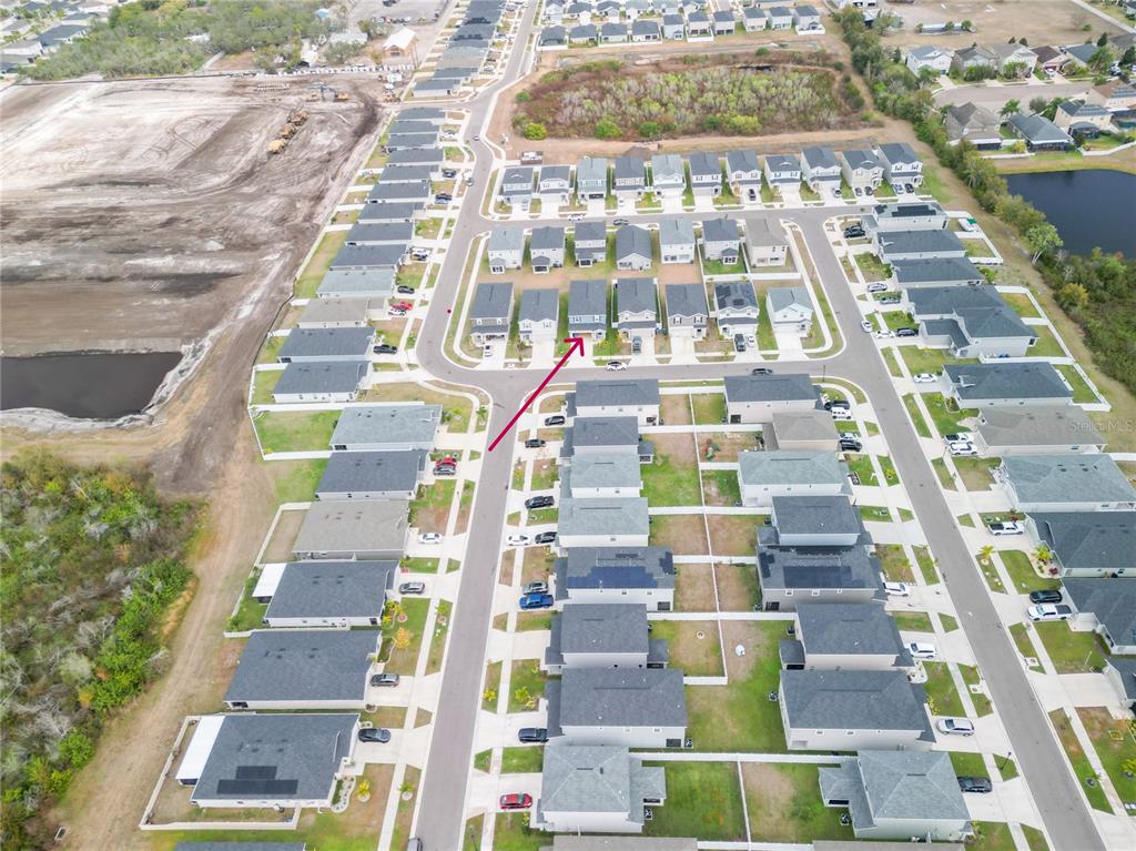This is an aerial view of a suburban residential neighborhood with a red arrow pointing to a house — 12288 CYPRESS BRANCH STREET, RIVERVIEW, FL