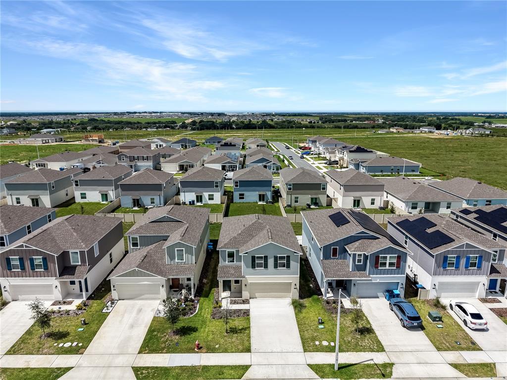 An aerial view shows a suburban neighborhood with rows of modern two-story houses — 2728 LOOKOUT RIDGE ROAD, LAKE HAMILTON, FL