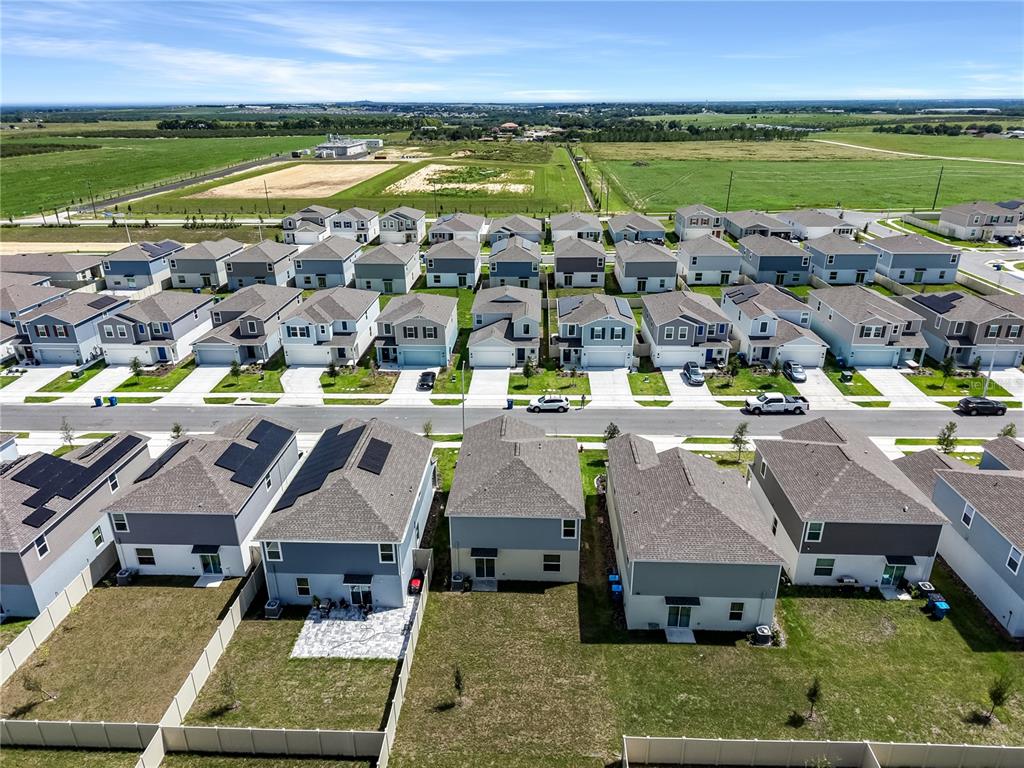 An aerial view shows a suburban neighborhood with rows of houses and surrounding green fields — 2728 LOOKOUT RIDGE ROAD, LAKE HAMILTON, FL