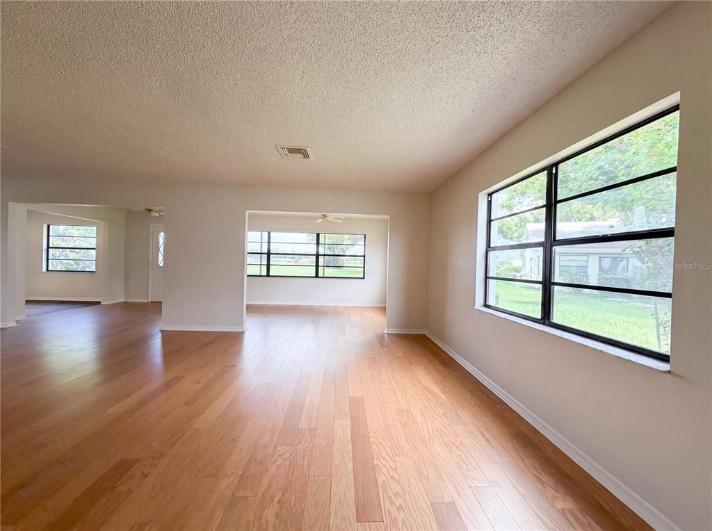 An interior view of a living room with hardwood floors and large windows — 1404 LELAND DRIVE UNIT 0, SUN CITY CENTER, FL
