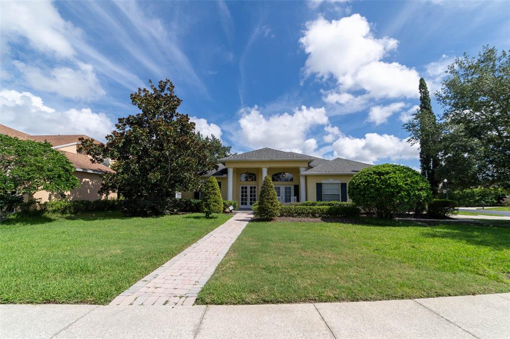 A single-story house with a paved walkway, columns, and a large front lawn — 2960 ASHTON TERRACE, OVIEDO, FL