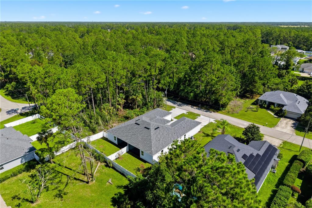 An aerial view shows a white house with a gray roof surrounded by green lawns — 6 UNICORN COURT UNIT A & B, PALM COAST, FL