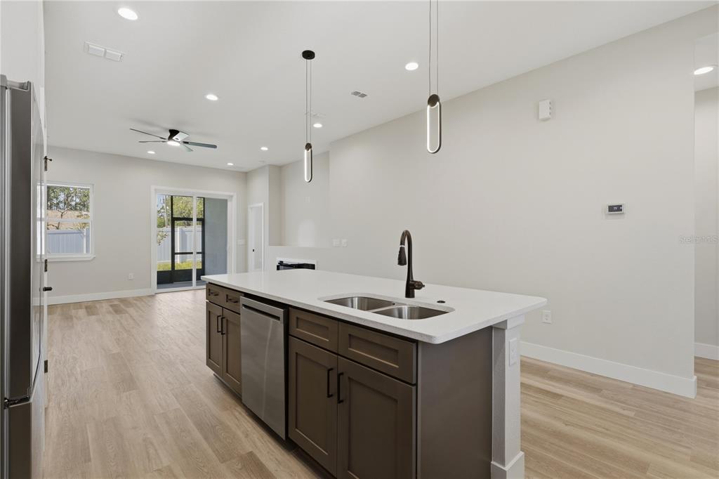 A kitchen island with a stainless steel dishwasher and sink sits in a modern room — 6 UNICORN COURT UNIT A & B, PALM COAST, FL