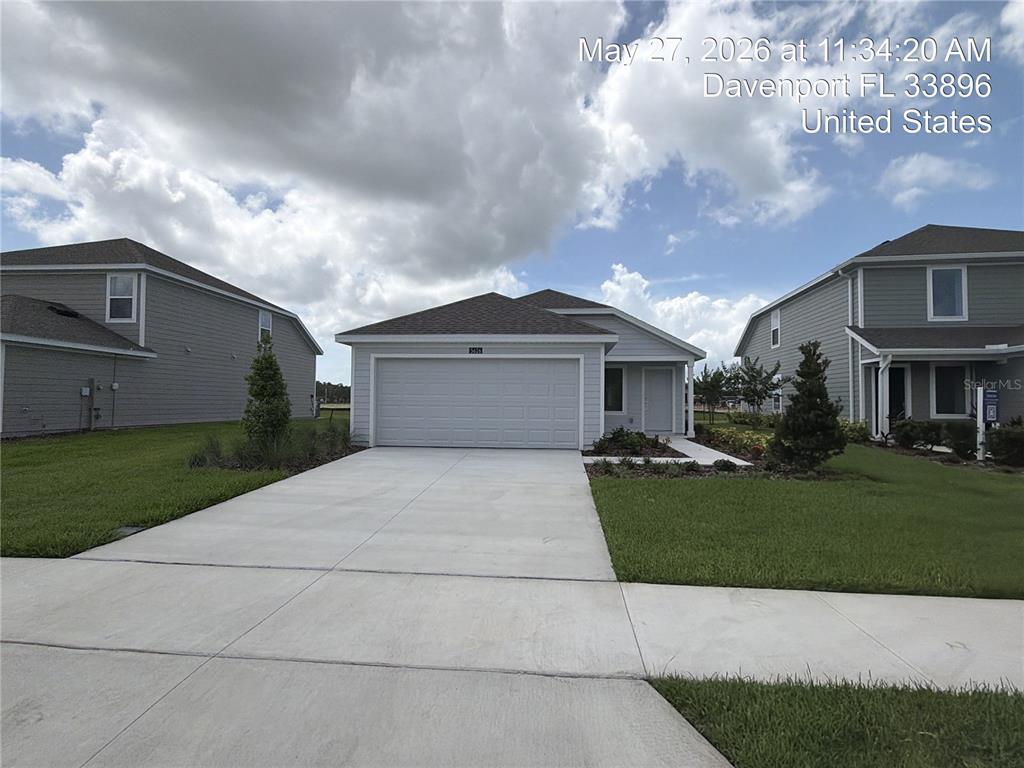 A light blue single-story house with a two-car garage and a landscaped front yard — 5626 MORANT BAY PATH, KISSIMMEE, FL
