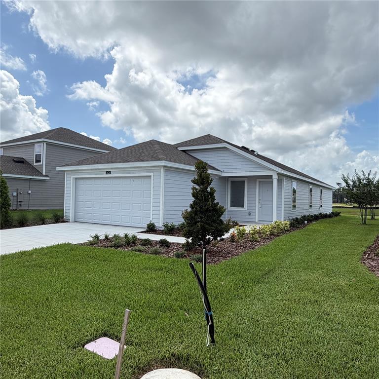 A light-colored, single-story house with a two-car garage and a landscaped front yard — 5626 MORANT BAY PATH, KISSIMMEE, FL
