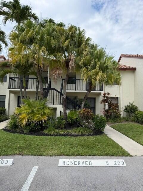 A two-story apartment building features palm trees, a staircase, and reserved parking spaces — 22088 Palms Way # 204, Boca Raton FL 33433, BOCA RATON, FL