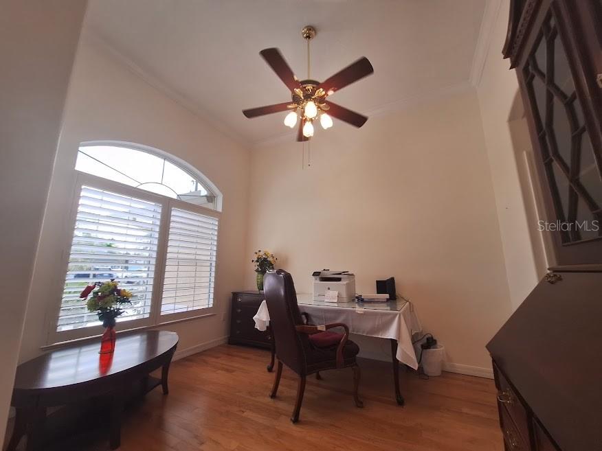 A home office features hardwood floors, a ceiling fan, a desk, and a large window — 39 EVANS DRIVE, PALM COAST, FL