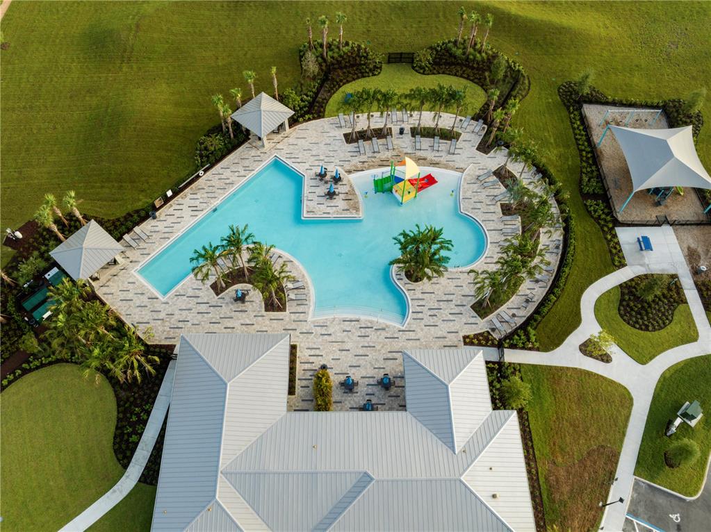 An aerial view shows a swimming pool with a splash pad and a nearby playground — 7276 ROLLING LEAF ROAD, GROVELAND, FL