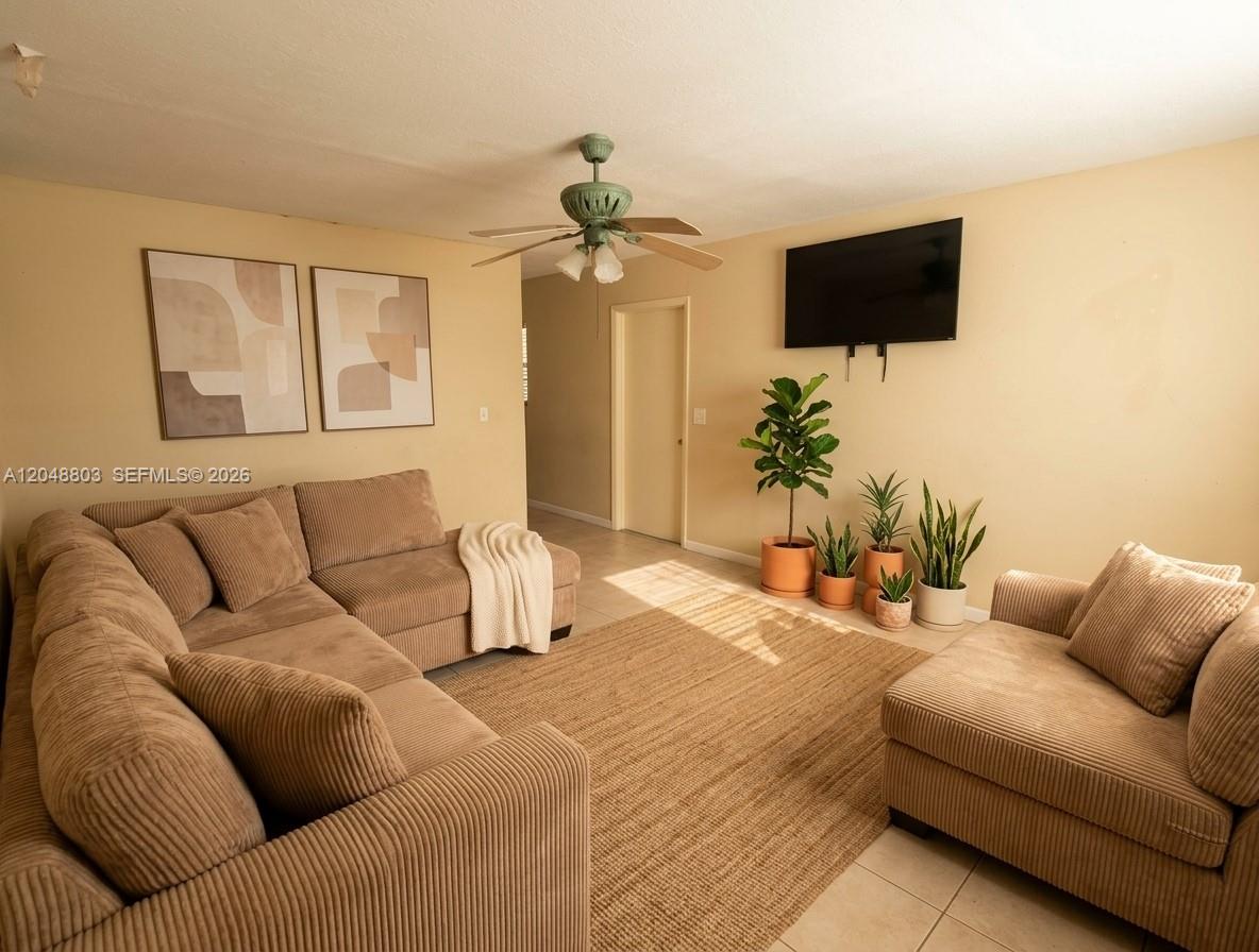 A living room features a tan sectional sofa, a matching loveseat, and several potted plants — 1829 N A St # 50, Lake Worth FL 33460, LAKE WORTH, FL