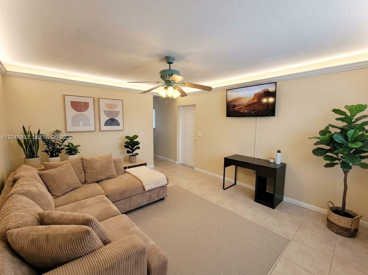 A living room features a tan sectional sofa, a ceiling fan, and a wall-mounted television — 1829 N A St # 50, Lake Worth FL 33460, LAKE WORTH, FL