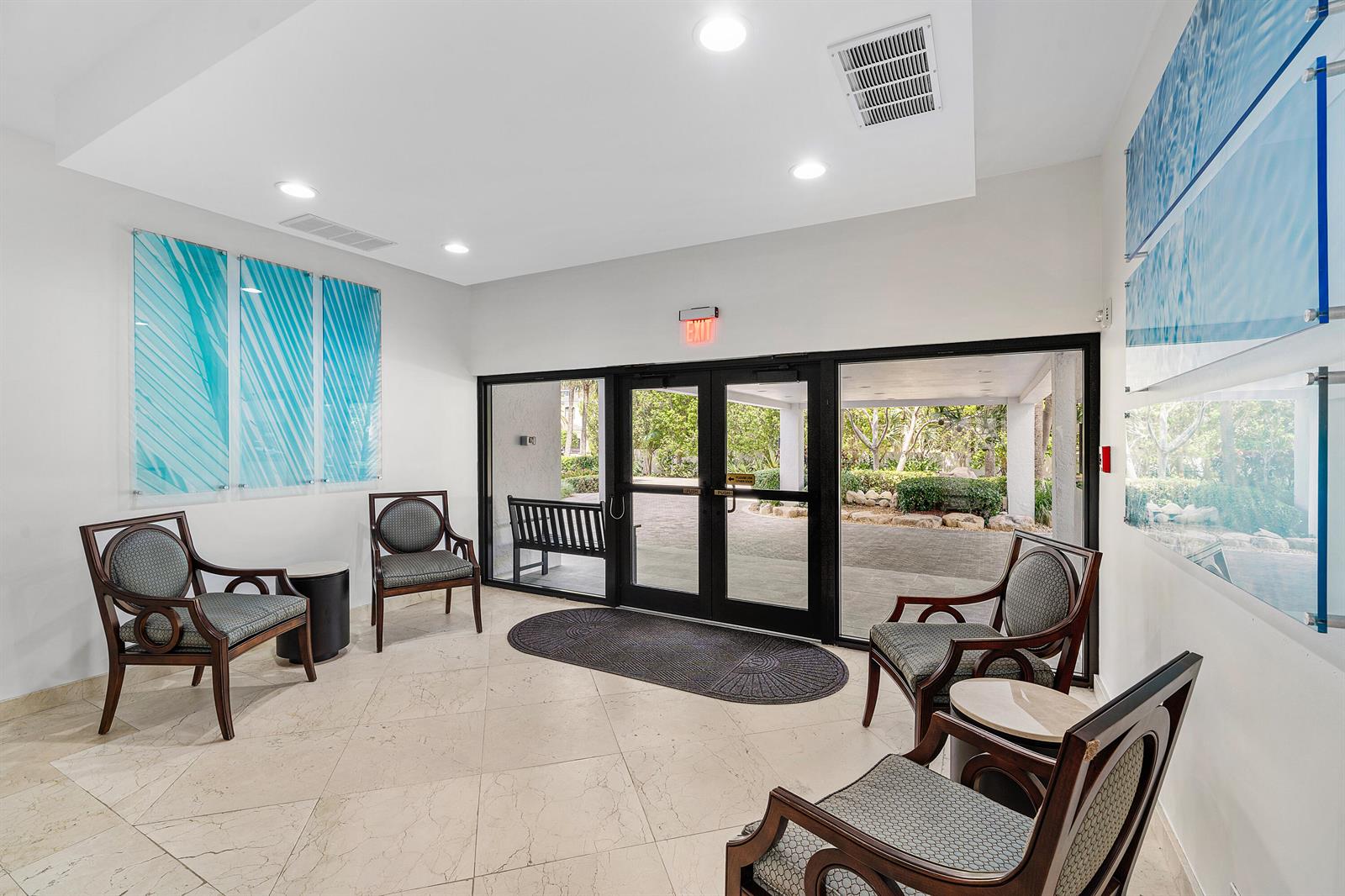 A waiting area features four armchairs, tiled floors, and glass doors leading to an outdoor walkway — 4600 S Ocean Boulevard # 602, Highland Beach FL 33487, HIGHLAND BEACH, FL